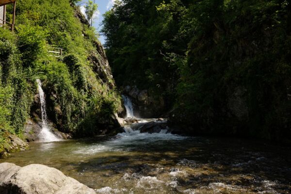 Üppiger Wald und ein Wasserfall im Malcantone