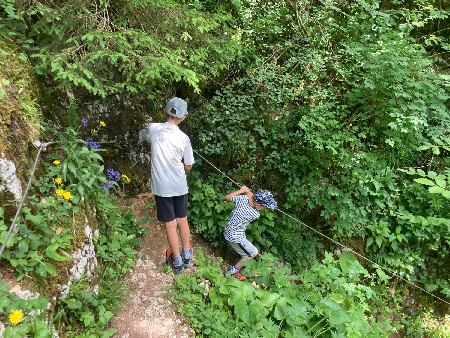 Un chemin raide, assuré par un câble, descend vers l’échelle. Photo: Anna Kocher