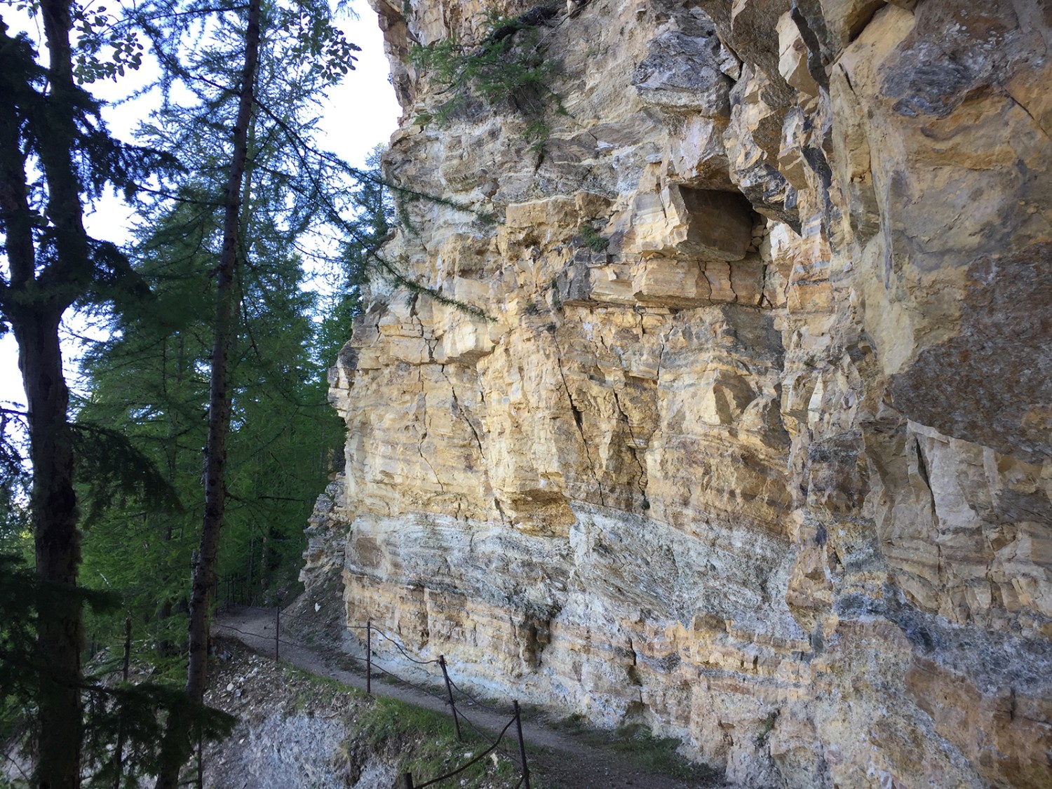 Au début de la randonnée, on longe de hautes parois rocheuses.