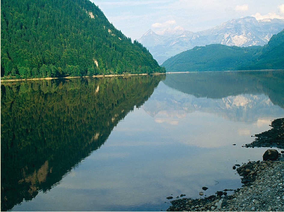 Im spiegelglatten Klöntalersee reflektieren sich die Berge.
