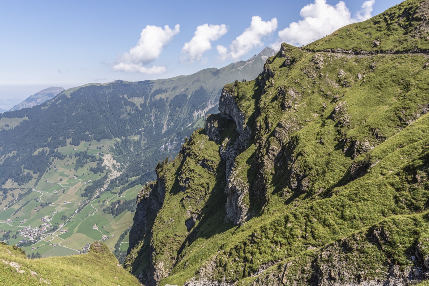 Ganz klein sind Wanderer auf der Krete zu erkennen. Wo das Gelände abschüssig ist, ist der Pfad talseitig mit einem Zaun versehen. Bild: Franz Ulrich