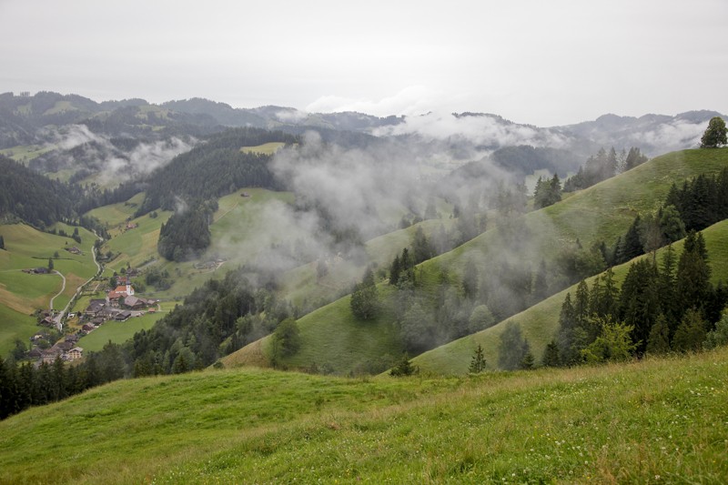Nebelverhangene Hügel. Unten im Tal das Dörfchen Trub. Bild: Daniel Fuchs
