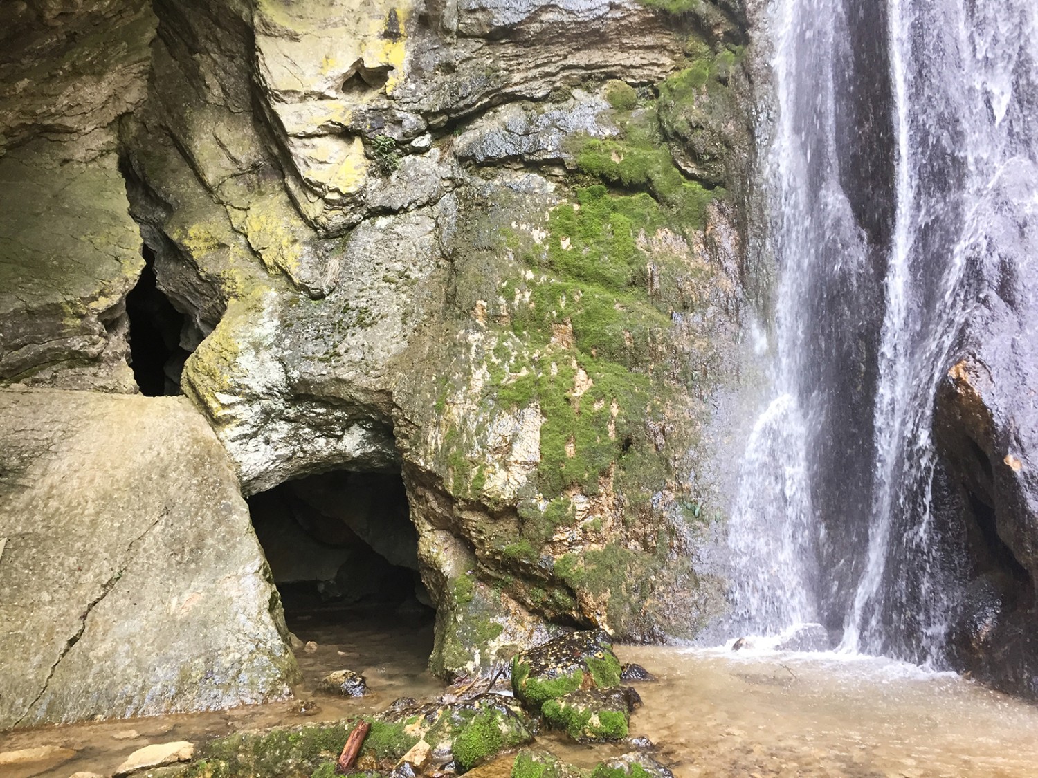 Dans la grotte, on marche dans l’eau. A gauche, la pierre à Rousseau. Photos: Rémy Kappeler