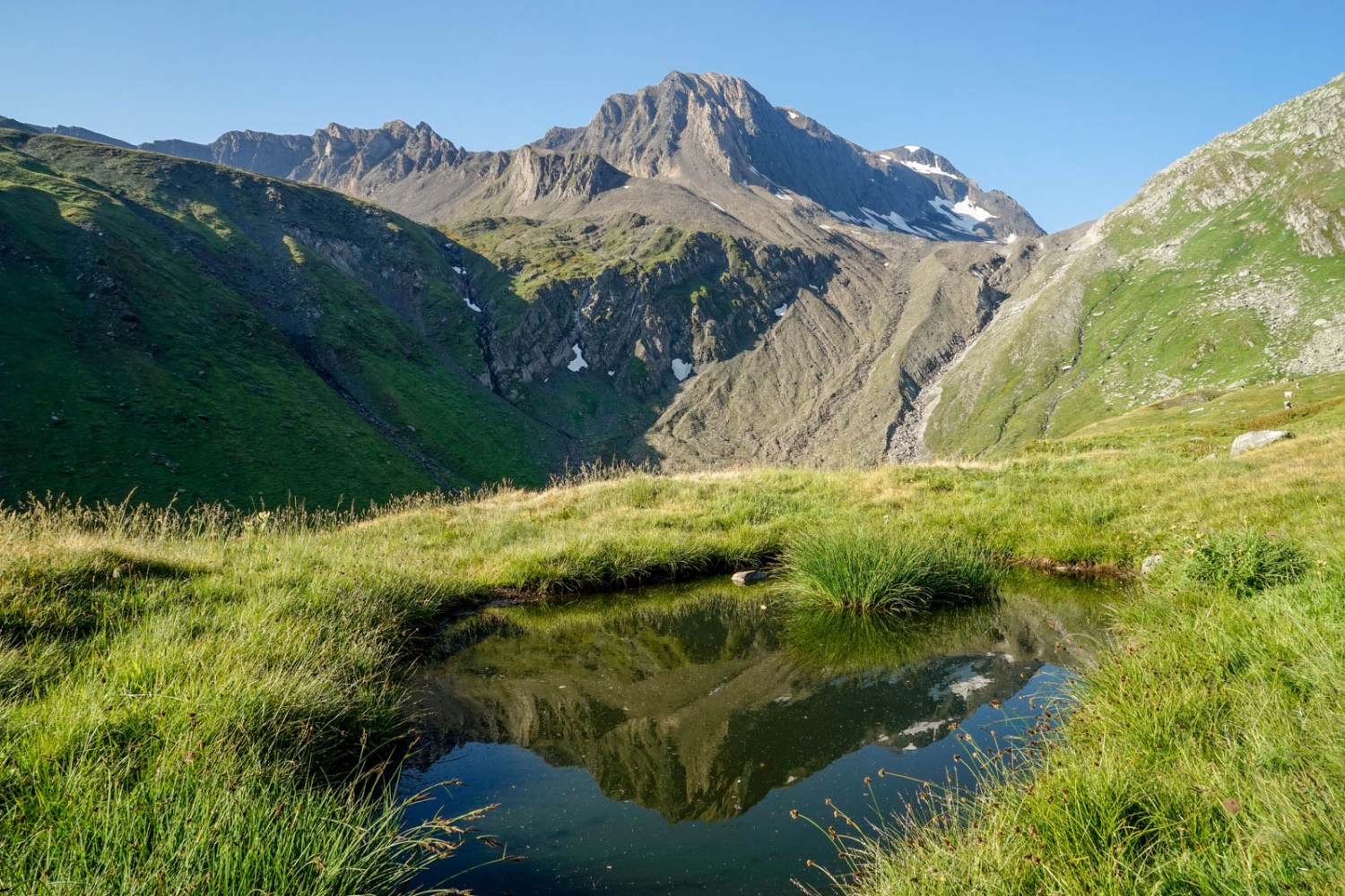 Les Ritzhörner se reflètent dans un étang du Lengtal. Photo: Fredy Joss