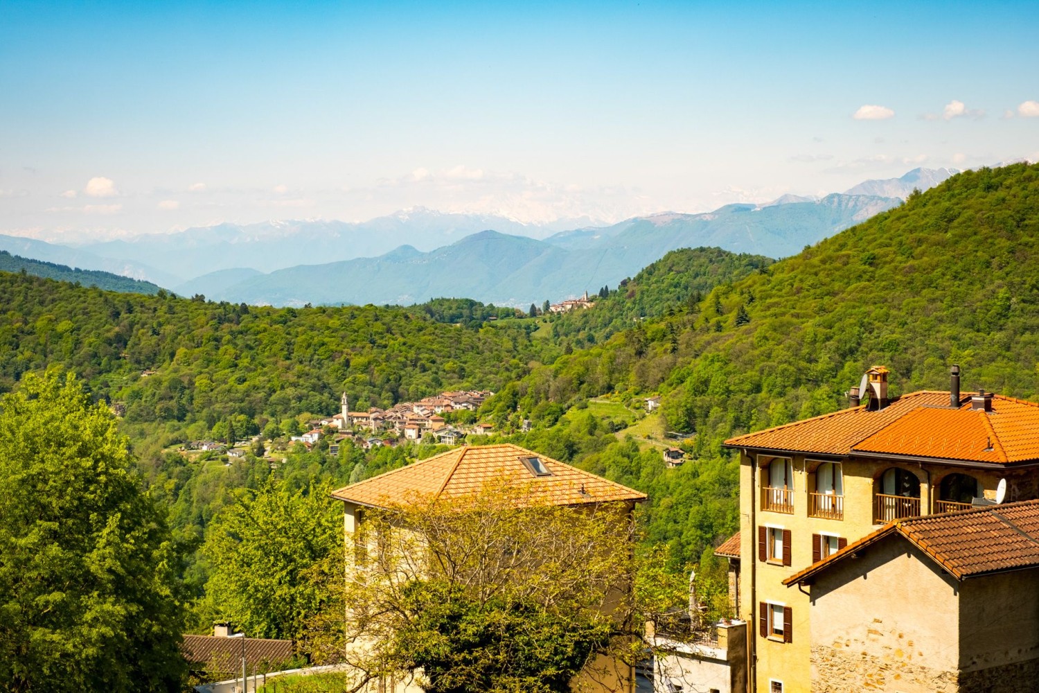 Curio e Bedigliora in primo piano. Sullo sfondo, il Monte Rosa avvolto dalla foschia.